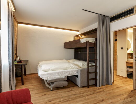 Doppelzimmer Hochwurzen mit Stockbett und Blick ins Badezimmer im 4-Sterne Hotel Rohrmoos bei Schladming