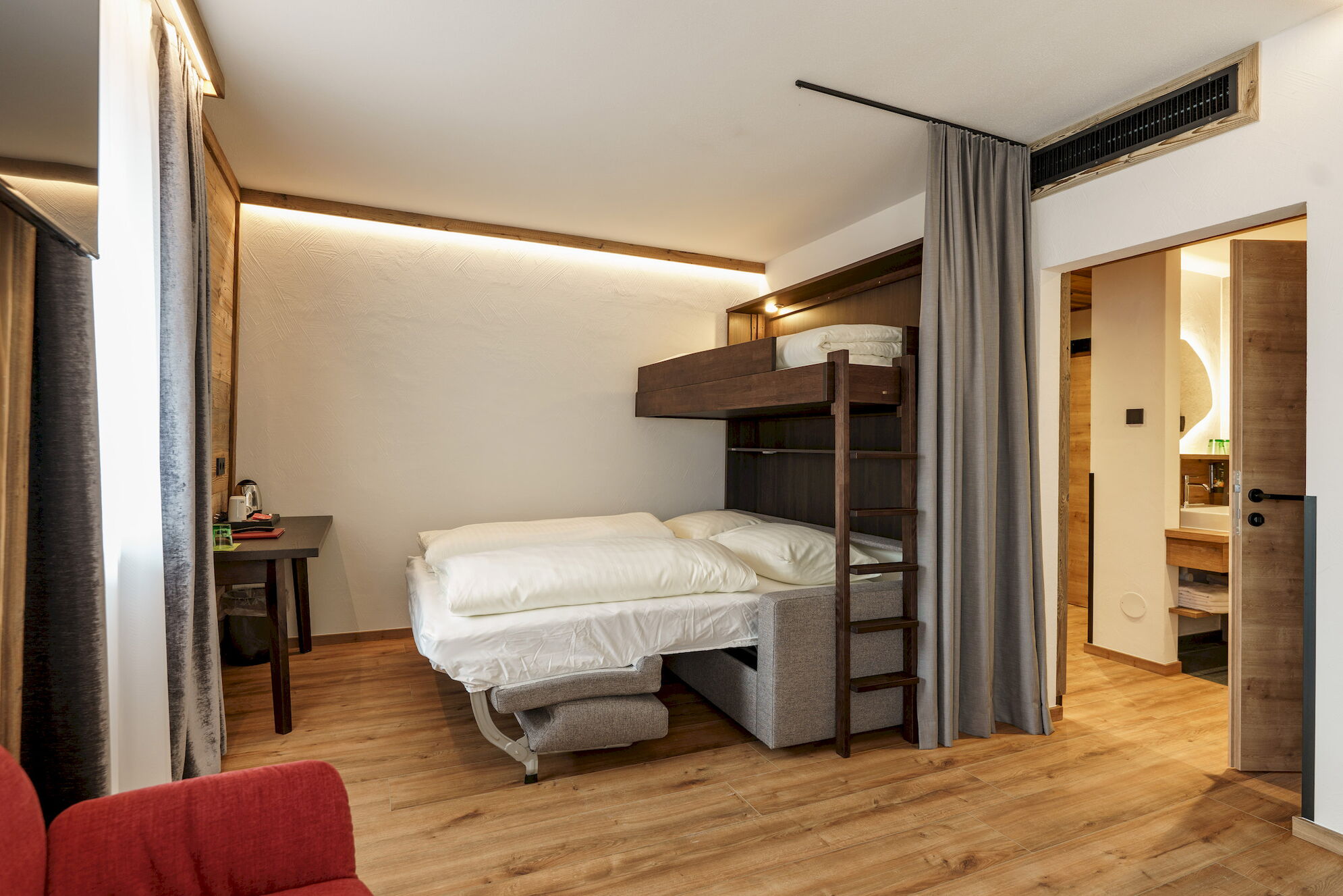 Doppelzimmer Hochwurzen mit Stockbett und Blick ins Badezimmer im 4-Sterne Hotel Rohrmoos bei Schladming